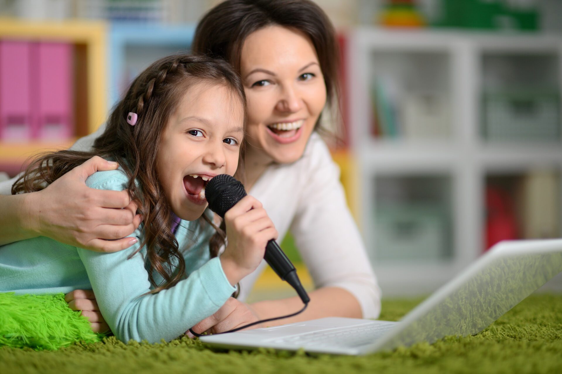 Mother and daughter looking at laptop computer singing karaoke